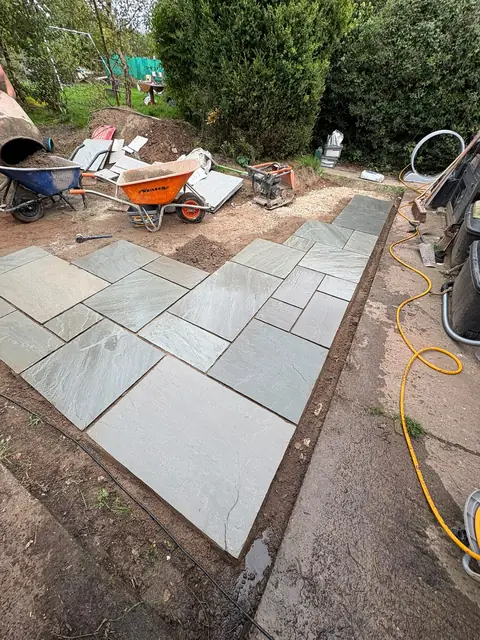 Sandstone slabs part way through being laid on a prepared base