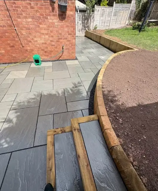 A path being laid against a new curved sleeper border