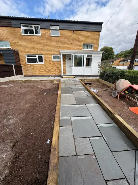 A new slab path laid with fresh topsoil either side