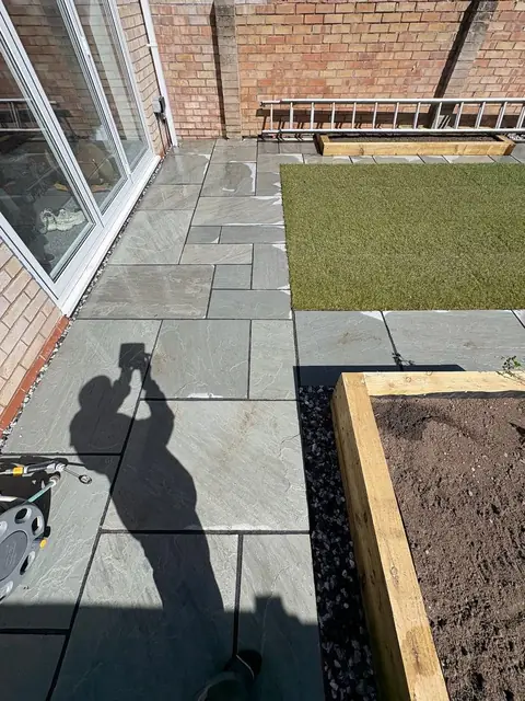 A sandstone patio laid beside a new lawn