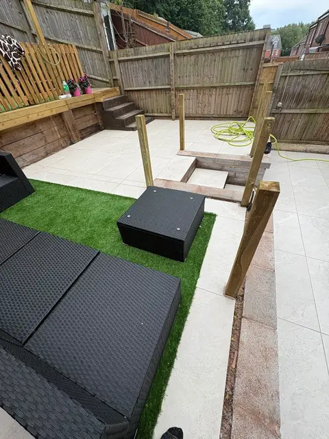 Black porcelain paving and a seating area with timber steps