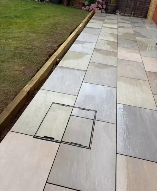A long grey slab path running the length of a garden