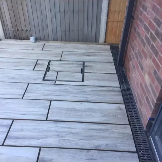 Patio slabs with a dark inset square detail set into the paving